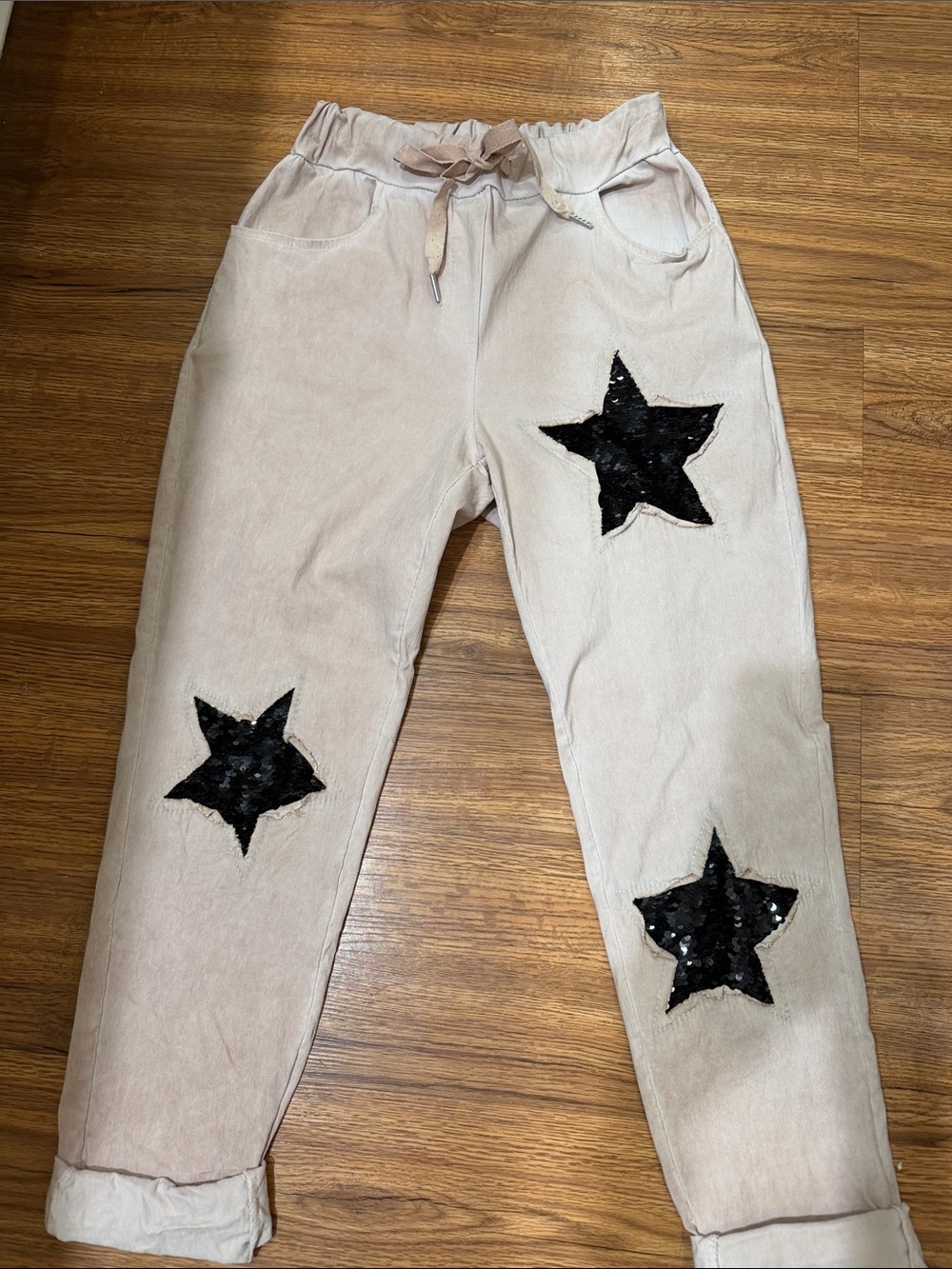 Women’s or juniors pink drawstring pants with sequin star patches.